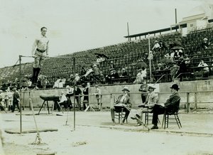 Horizontale foto van een atleet op een hoge stang met drie juryleden die toekijken